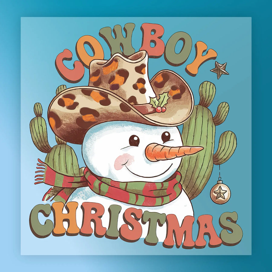 A smiling snowman in a cowboy hat and striped scarf stands by cacti with festive accents. Cowboy Christmas is written in bold. The InkMerge Cowboy Christmas Snowman Design is perfect for holiday DTF heat press transfers.