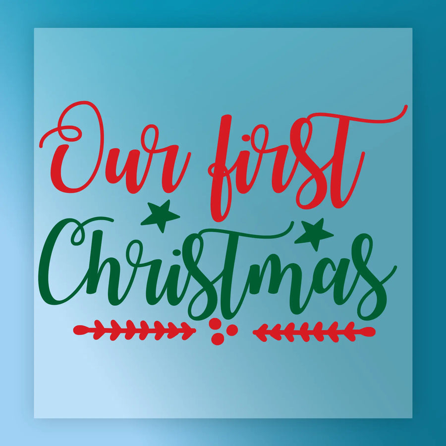 Text reads Our First Christmas in festive red and green script with stars and branches on a light blue background. This InkMerge Our First Christmas Design is a premium DTF transfer ideal for your holiday heat press projects.