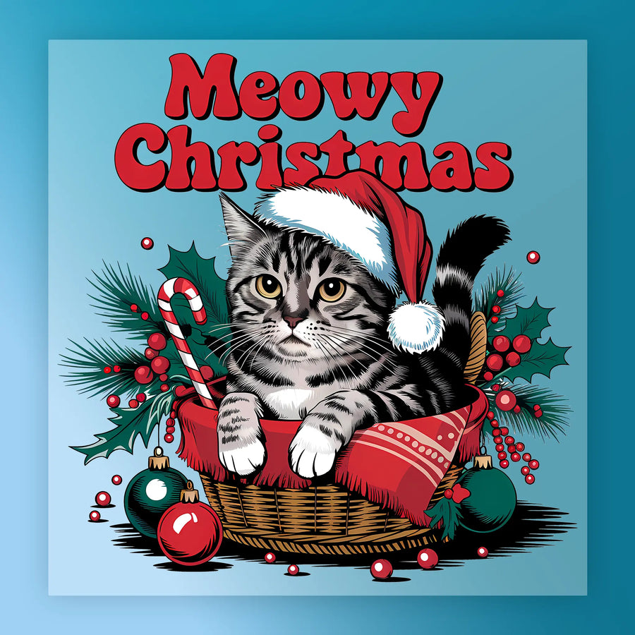The Meowy Christmas Cat Design by InkMerge features a tabby cat in a Santa hat sitting in a basket with a red blanket, holly, ornaments, and a candy cane—topped with bold "Meowy Christmas" text—perfect for DTF transfers or heat press projects.