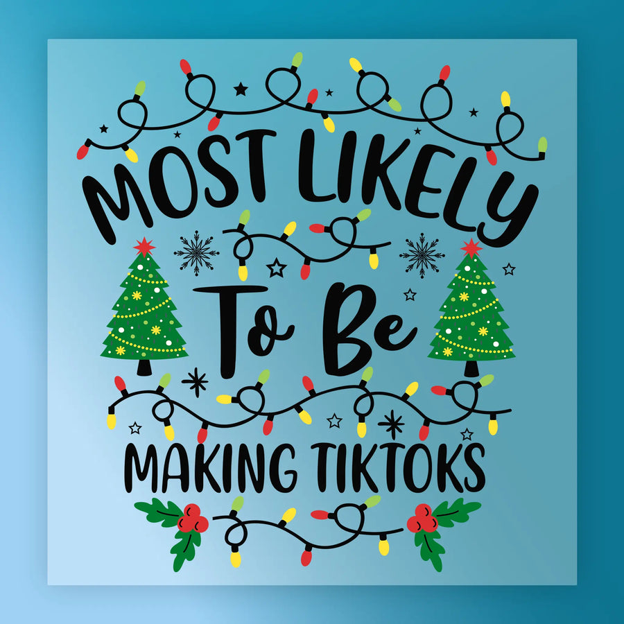 The "Most Likely To Be Making TikToks" design by InkMerge features colorful Christmas lights, decorated trees, snowflakes, and holly on a light blue gradient—ideal DTF transfer for your heat press using premium DTF film.