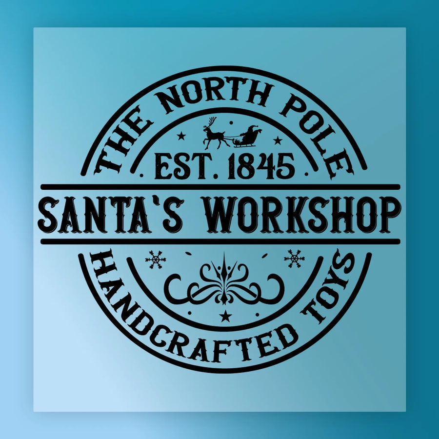 The North Pole Santa's Workshop Design by InkMerge: a circular vintage black stamp on light blue, with "The North Pole, Est. 1845, Santa's Workshop, Handcrafted Toys," sleigh, reindeer & stars—precut DTF transfer ready to press.