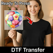 A woman holding a colorful watercolor painting of a soccer ball with a heart on it, and there is a red arrow pointing to her chest.