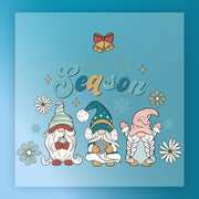 Three festive gnomes with flowers and snowflakes stand under “’Tis the Season” on a blue, starry background. The InkMerge Tis the Season Gnome Design is heat press ready—perfect for your next project!.