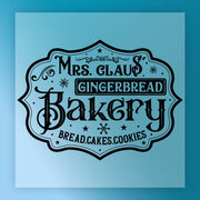 The InkMerge Mrs. Claus' Gingerbread Bakery Sign features vintage fonts, snowflakes, and swirls on a blue background—perfect for custom apparel transfers or as a charming Mrs. Claus' Gingerbread Bakery DTF transfer.