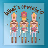 InkMerge's "What's Crackin' Nutcracker Humor" features three vibrant nutcracker soldiers in tall hats, each holding a nut beneath playful text and scattered stars—a festive, funny design ideal for your holiday heat press projects.