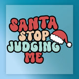 Bright, retro-style letters spell out InkMerge’s Santa Stop Judging Me Design—ideal for your next ugly sweater party. “Judging” stands out in light green with a Santa hat on the G, all set on a blue background.