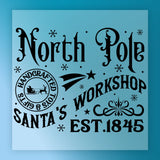 The North Pole Handcrafted Toys & Gifts Design by InkMerge features black vintage text on blue with stars, snowflakes, a sleigh and reindeer—ideal for DTF transfers or custom apparel using your heat press.