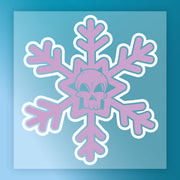 A stylized purple snowflake with a cartoon skull center on a blue gradient background, the Gothic Skull Snowflake Design by InkMerge is perfect for DTF or heat press transfers that blend winter and spooky styles.