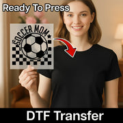 A smiling woman holding a sign with a soccer ball and the text "SOCCER MOM" on it.