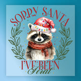 InkMerge’s Funny Christmas Raccoon Design features a raccoon in a festive hat and scarf with green leaves on a blue background, plus “Sorry Santa” and “I’ve been feral”—perfect for your holiday shirt transfers!.