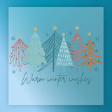 The Warm Winter Wishes Vintage Design by InkMerge features six colorful, stylized Christmas trees on a blue, snowflake background with “Warm winter wishes” below in elegant script, perfect for retro garment transfers.