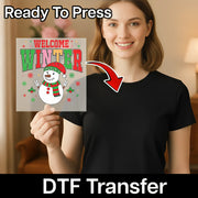 A woman holding a sign with a snowman and winter-themed design, with a red arrow pointing to her chest.