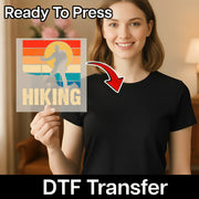 A smiling woman in a black shirt holds InkMerge’s “Retro Surfing Sunset” heat press transfer sheet featuring a retro sunset and surfer graphic. Text above says Ready To Press with a red arrow pointing to the blank shirt.