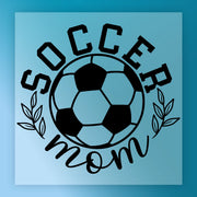 a soccer ball with the text "SOCCER MOM" written around it, along with some leaves.