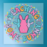 a colorful, circular design with the text "Teaching some bunny" written around it. The design includes a pink bunny, a purple bunny, and a blue bunny, all set against a blue background with a pattern of colorful squares.