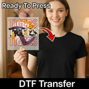 A woman is holding up a sign with the word "TIGERS" on it, and there is a red arrow pointing to her chest.