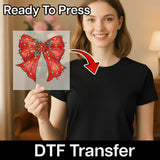 A smiling woman in a black shirt holds a transparent Festive Red Bow with Poinsettia and Lights Design by InkMerge. Text reads “Ready To Press + DTF Transfer” with a red arrow—ideal for your next creative project!.