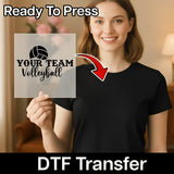 A woman holding a sign with the text "YOUR TEAM Volleyball" and a red arrow pointing to her chest.