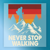A hiker silhouette with a backpack stands on mountain peaks, surrounded by pines and a retro sunset. The InkMerge Retro Mountain Sunset Design DTF transfer features bold “NEVER STOP WALKING” text, perfect for heat press application.