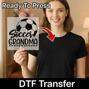 A smiling woman holding a sign with a soccer ball and the text "Soccer Grandma" on it.