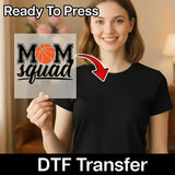 A smiling woman holding a sign with the text "MOM squad" on it, with a red arrow pointing to the sign.