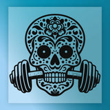 A stylized illustration of a skull with intricate floral patterns and designs, holding a barbell in its mouth.