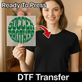 A smiling woman holding a sign with the word "SOCCER BROTHER" on it, with a red arrow pointing to her chest.