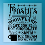 The InkMerge Frosty's Snowflake Cafe Christmas Design reads: "Frosty's Snowflake Cafe. Cookies, Hot Chocolate, Santa, Ice Cream. Open All Winter." Features snowflakes and a hot chocolate mug—ideal for ugly sweater parties! Heat press ready.