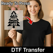 A woman in a black shirt holds an InkMerge "Camp More Worry Less Pine Tree Tent" DTF sheet with a Christmas tree and tent design. Ready to press—perfect camping shirt or holiday heat press transfer!.