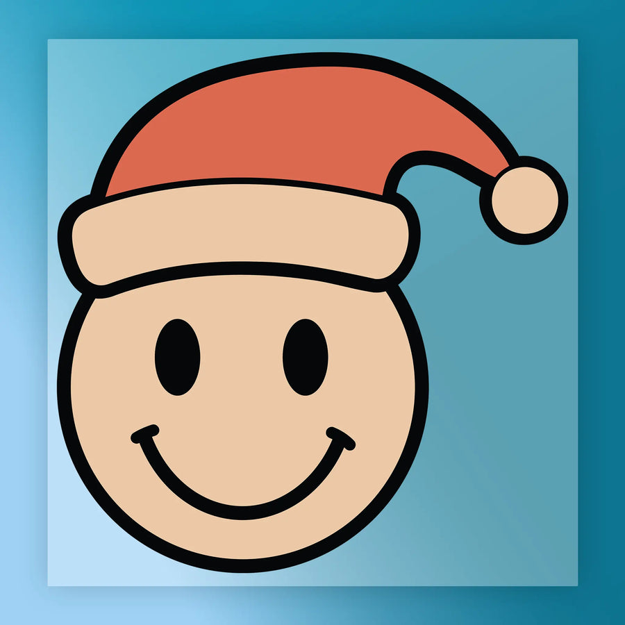 The InkMerge Smiley Face Santa Hat Design features a cheerful cartoon smiley with a Santa hat on blue, perfect for festive holiday apparel made with DTF transfer and heat press.