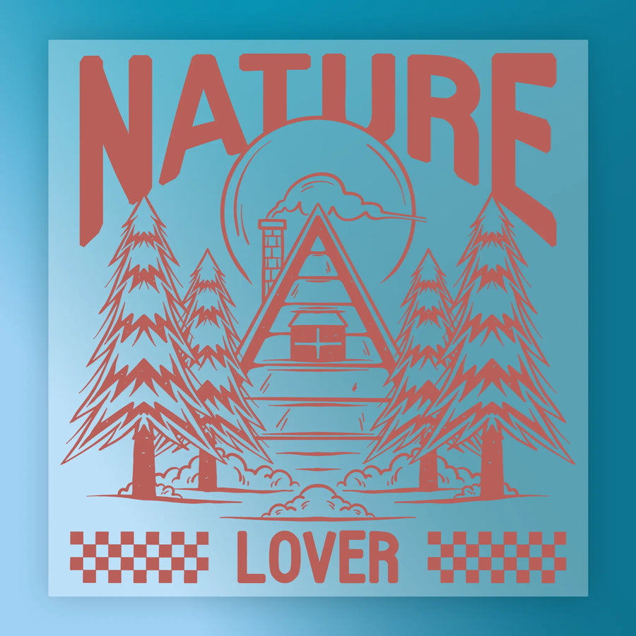 Nature Lover - Heat Press Ready by InkMerge features a cabin amid tall pines, with "NATURE" on top and "LOVER" below, set on a blue background with sun and clouds—ideal for premium DTF film or heat press transfers.