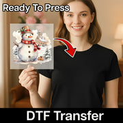 A smiling woman in a black shirt holds an InkMerge "Traditional Christmas Snowman Scene" DTF transfer sheet, featuring a snowman with hat and scarf, snowy trees, and a church—perfect for your heat press projects.