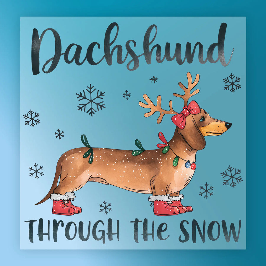 InkMerge’s "Dachshund Through The Snow" features a dachshund in red boots, antlers, bow, and Christmas lights with snowflakes on a blue background—ideal for heat press or DTF transfer projects.
