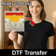 A smiling woman in a black shirt holds an InkMerge Abstract Sunset Over Mountains DTF transfer. Text on the image reads Ready To Press and DTF Transfer, with an arrow pointing to the colorful design.
