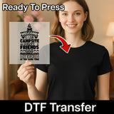 A smiling woman in a black t-shirt holds a clear InkMerge "Welcome to Our Campsite Quote" DTF transfer featuring camping-themed text. An arrow points from the sheet to her shirt. Text: Ready To Press & DTF Transfer for custom apparel.