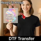A smiling woman in a black tee holds an InkMerge Retro Merry Christmas DTF transfer sheet. Text reads "Ready To Press" and "DTF Transfer," with an arrow pointing to her shirt.