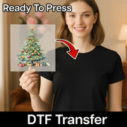 A smiling woman in a black shirt holds InkMerge’s Classic Christmas Tree Design - Heat Press Ready DTF transfer sheet, with an arrow pointing to her shirt. Perfect for custom holiday apparel! Text reads Ready To Press and DTF Transfer.