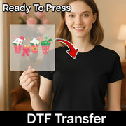A smiling woman in a black shirt holds a transparent "Festive Holiday Drinks Design" DTF transfer sheet by InkMerge. Text reads "Ready To Press" at the top and "DTF Transfer" at the bottom, with an arrow to the heat press-ready sheet.