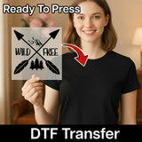 A woman holding a sign with the text "WILD FREE" and a graphic of a feather and mountain.