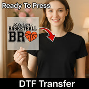 A smiling woman holding a sign with a basketball and heart design, with a red arrow pointing to the sign.