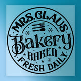 The Mrs. Claus Bakery Vintage Design by InkMerge features black text and decorative snowflakes with utensils on a light blue background—ideal for vintage design transfers or custom apparel.