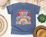Teaching Tiny Humans To Do Big Things graphic tee in Blue Jean