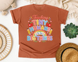 Teaching Tiny Humans To Do Big Things graphic tee in Yam