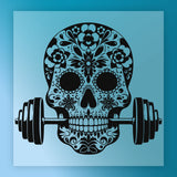 A stylized black and white illustration of a skull with intricate floral and floral designs, positioned in front of a set of dumbbells.