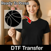 A woman is holding up a stencil of a basketball, with a red arrow pointing to her chest, indicating that she is ready to press the stencil onto her shirt.