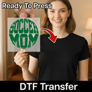 A smiling woman holding a sign with the word "SOCCER MOM" on it, with a red arrow pointing to her chest.