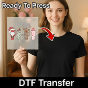 A smiling woman in a black shirt holds a transparent sheet with the InkMerge Festive Drinkware Holiday Design. "Ready to Press" appears above, "DTF transfer" below, and an arrow shows easy heat press application from sheet to shirt.