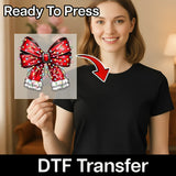 A smiling woman in a black shirt holds the InkMerge Festive Red Bow Christmas Lights Design DTF transfer, featuring "Ready To Press" text above and "DTF Transfer" below—perfect for your next ugly sweater party!.