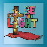 The BE THE LIGHT Christmas Design by InkMerge features an illustrated wooden cross with string lights beside bold letters and Matthew 5:14 on a red cloth—ideal for DTF transfers and custom apparel.