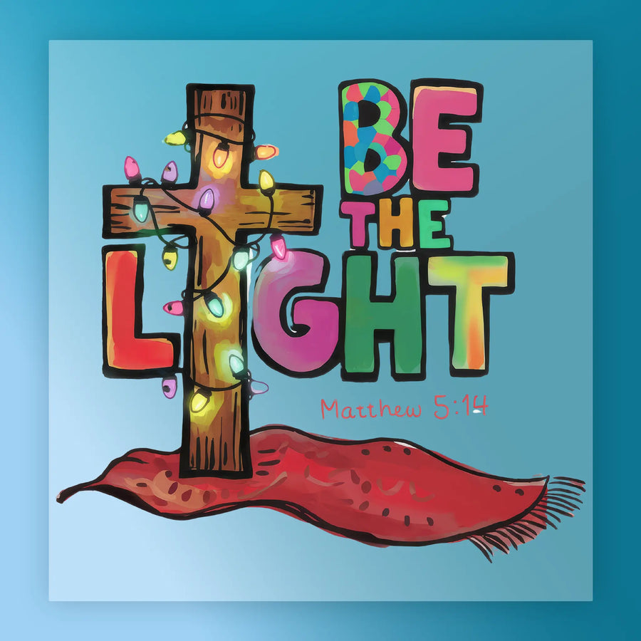 The BE THE LIGHT Christmas Design by InkMerge features an illustrated wooden cross with string lights beside bold letters and Matthew 5:14 on a red cloth—ideal for DTF transfers and custom apparel.